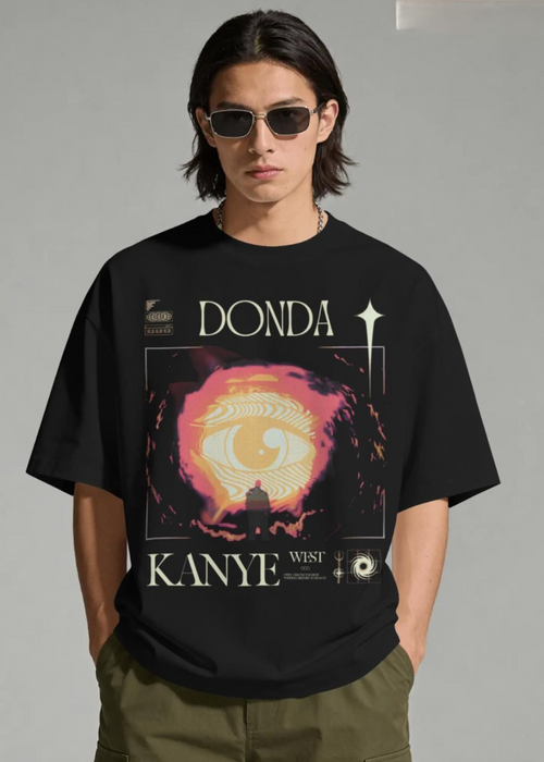 Person wearing a black t-shirt with 'Donda' and 'Kanye West' graphic design.