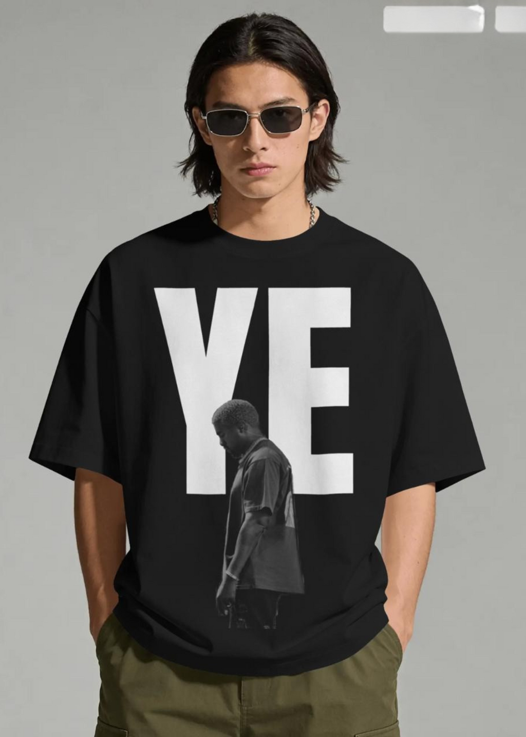Person wearing a black t-shirt with 'YE' and a silhouette of a person on a gray background