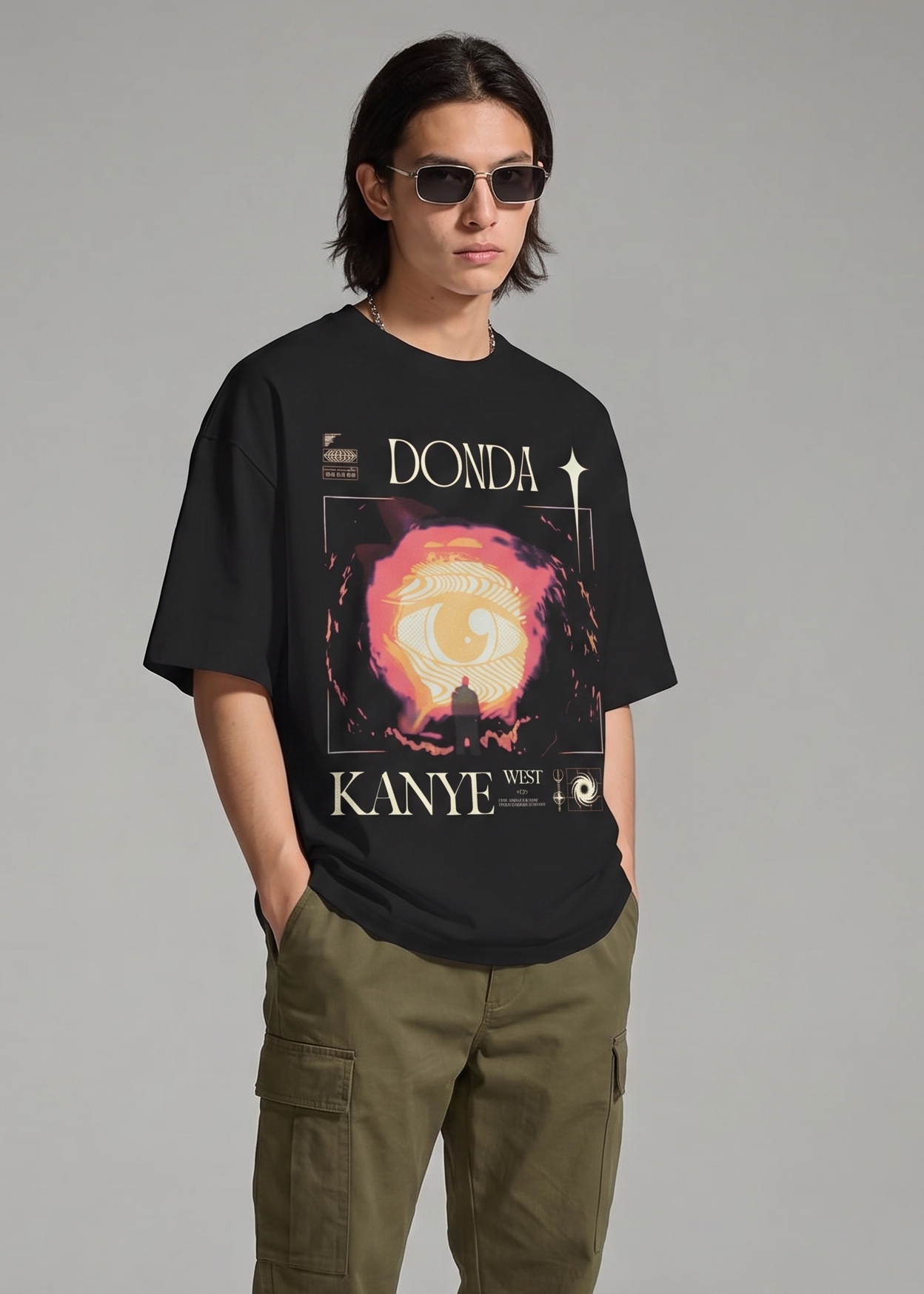 Person wearing a black t-shirt with 'Donda' graphic and green cargo pants on a gray background