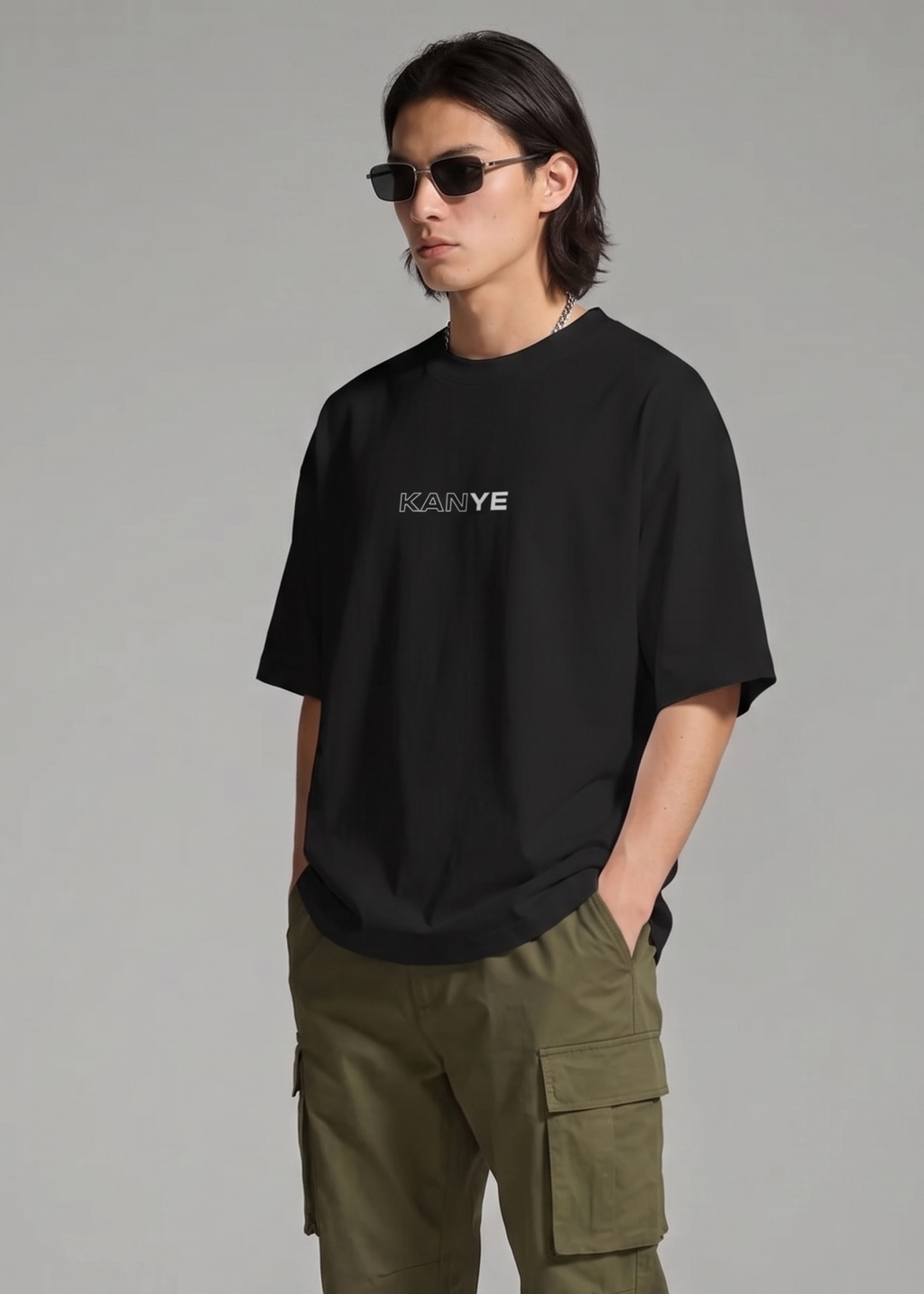 Person wearing a black t-shirt with a logo and green cargo pants on a gray background