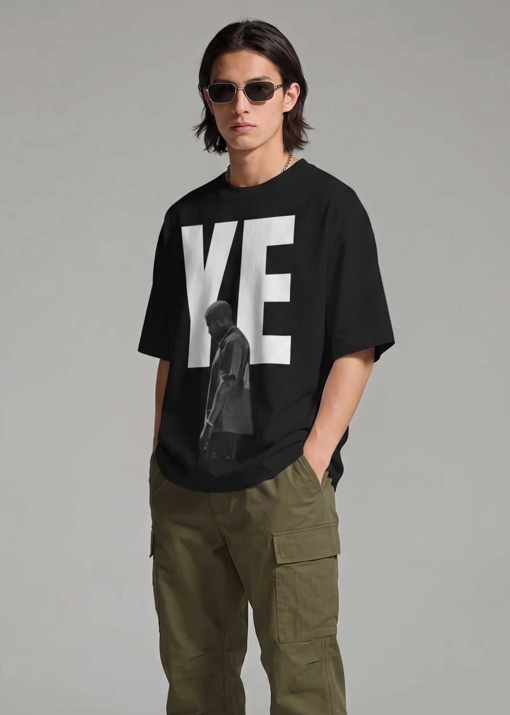 Person wearing a black t-shirt with a graphic design and green cargo pants on a gray background