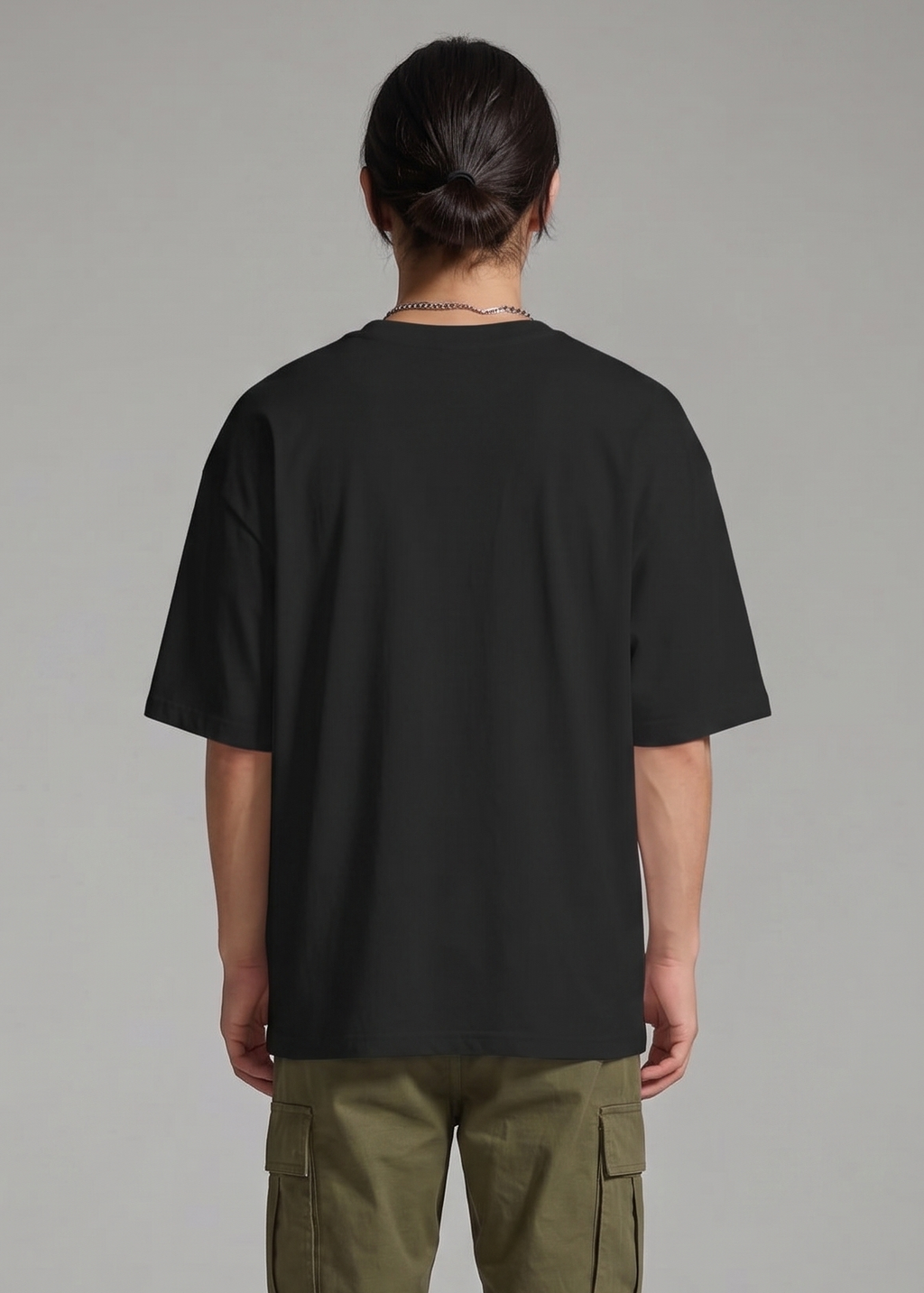 Person wearing a black t-shirt and green cargo pants on a gray background